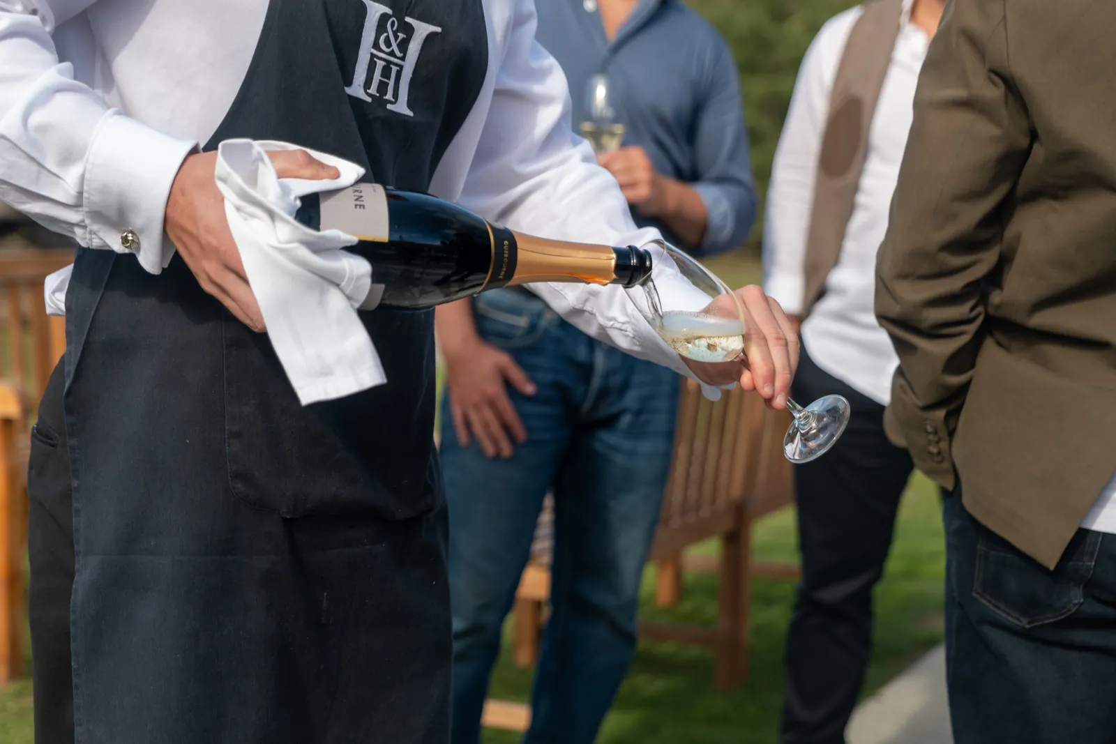 Champagne being poured for guests at a charity clay shoot