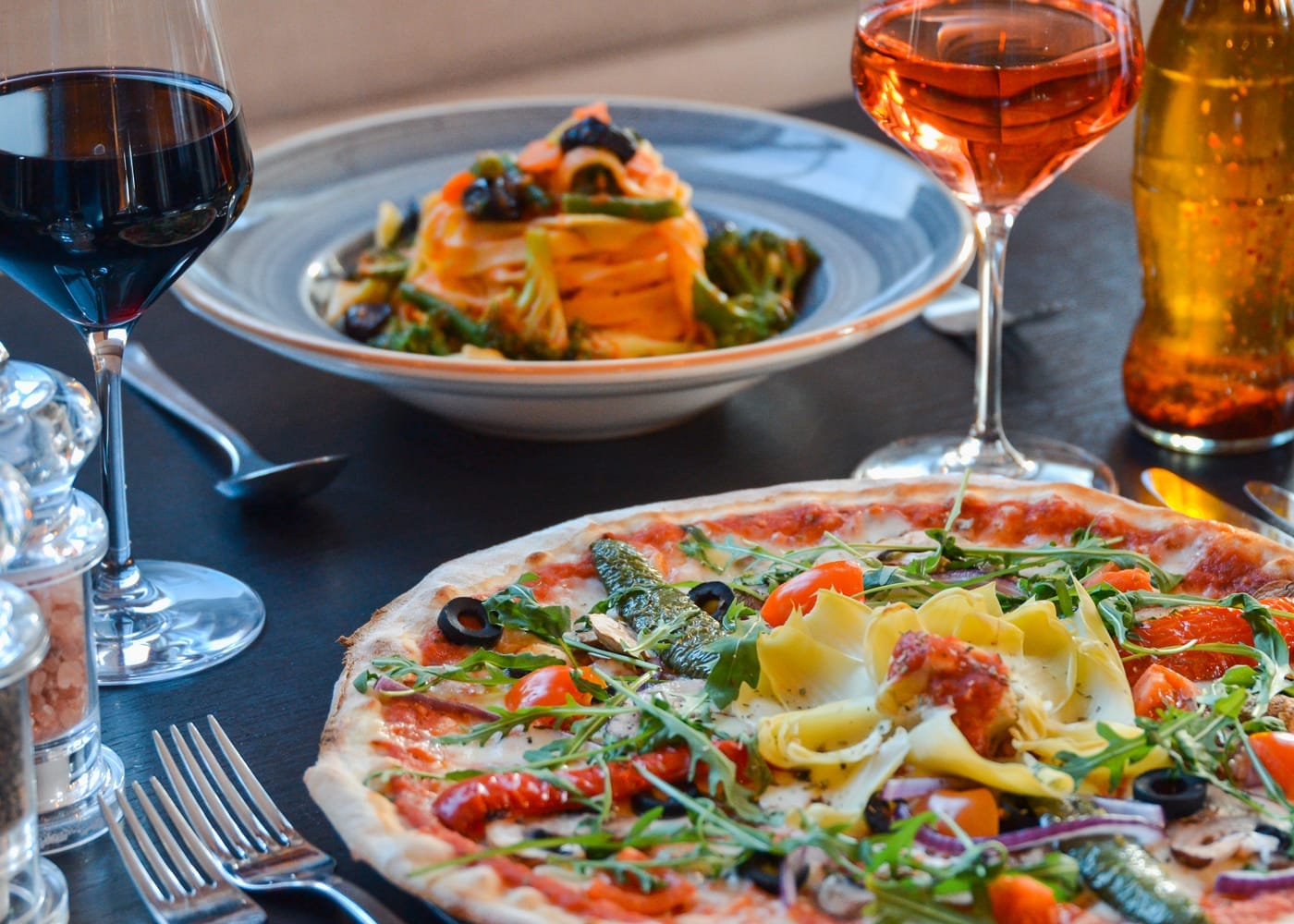 Pizza, pasta and drinks on a restaurant table