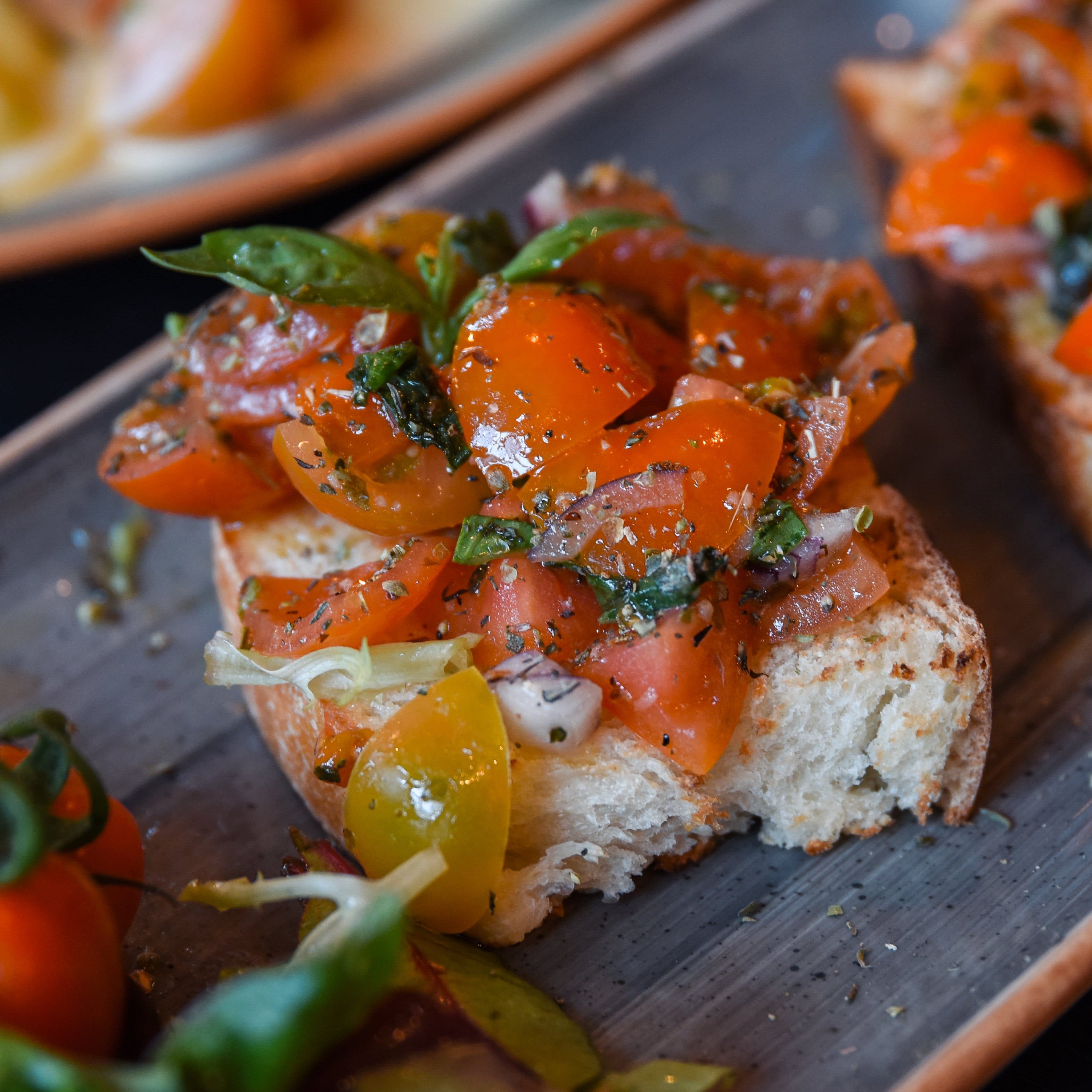 Tomato bruschetta with basil on a board