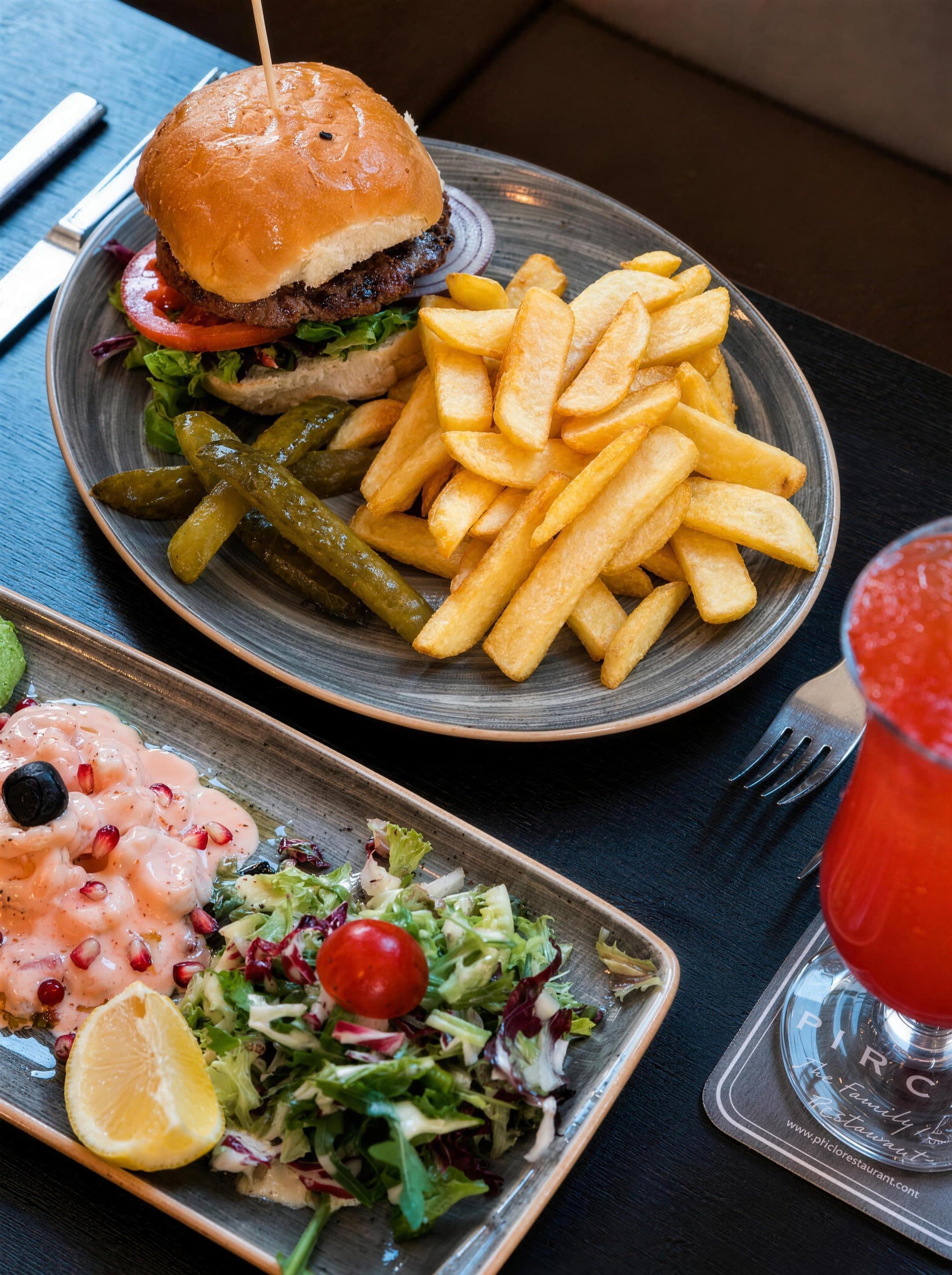 A burger with fries and a prawn salad